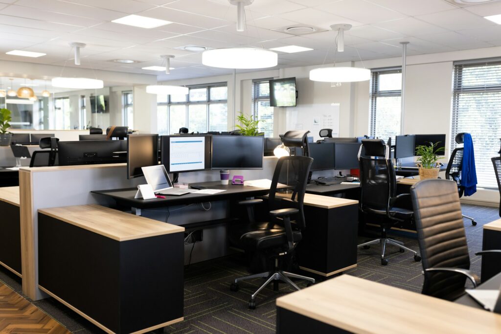 Empty open space office with desks, chairs and computers