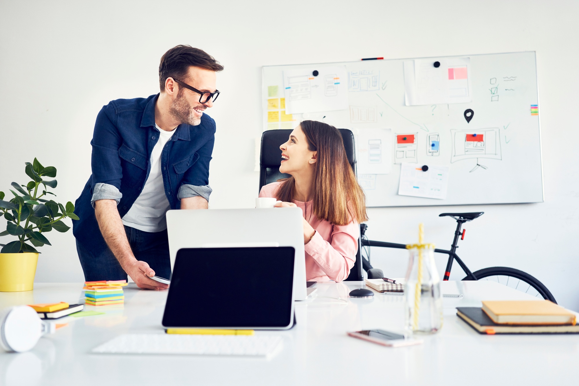 Two colleagues working together on laptop in office
