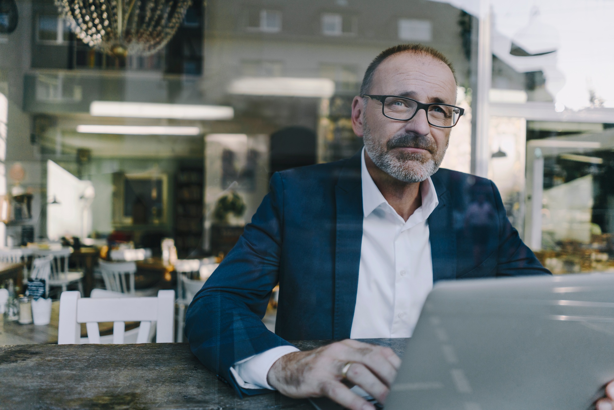 Businessman working in a coffee shop, using laptop
