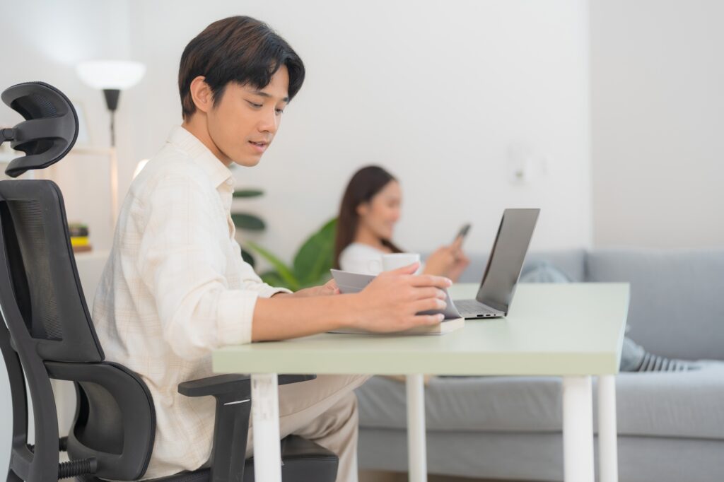 Modern home office with working man and relaxing woman