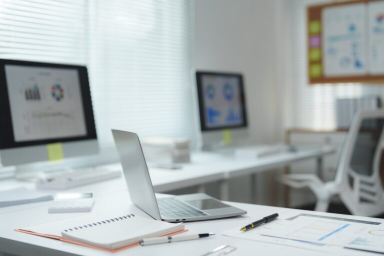 Modern office desk showing productivity and business charts on screens