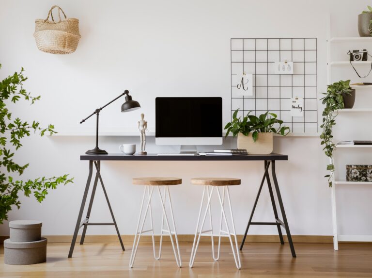 Stools at desk with lamp and desktop computer in freelancer's in