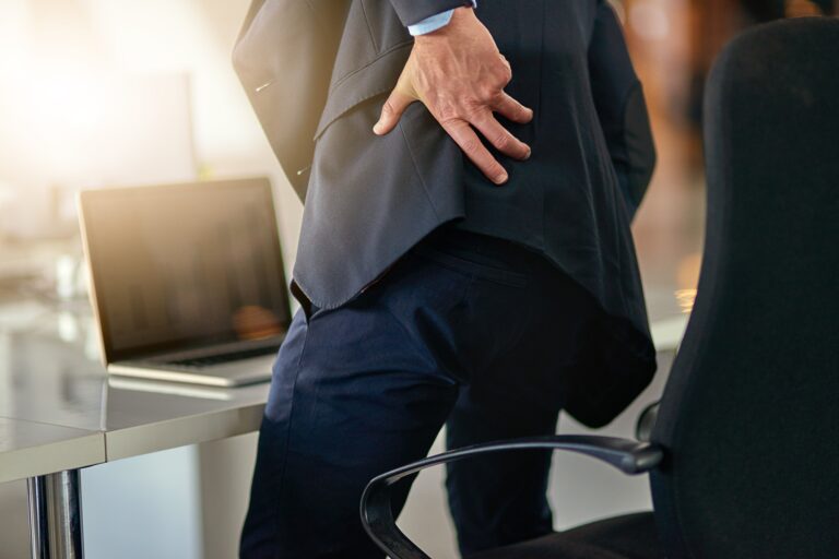 Time for a new office chair. Shot of a businessman suffering from back pain.